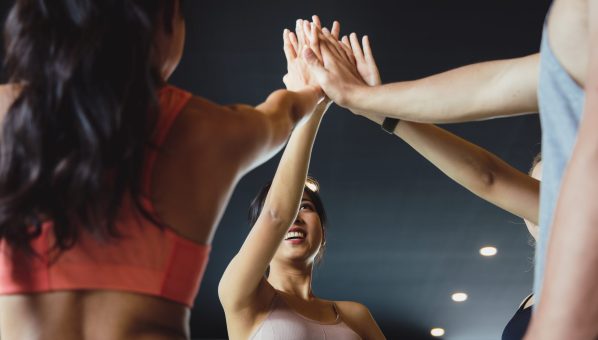 A group of young Asian people who are in good shape at the gym. Picture of cheerful fitness team in gym.They coordinated their hands. Concepts of exercise for health and good shape
